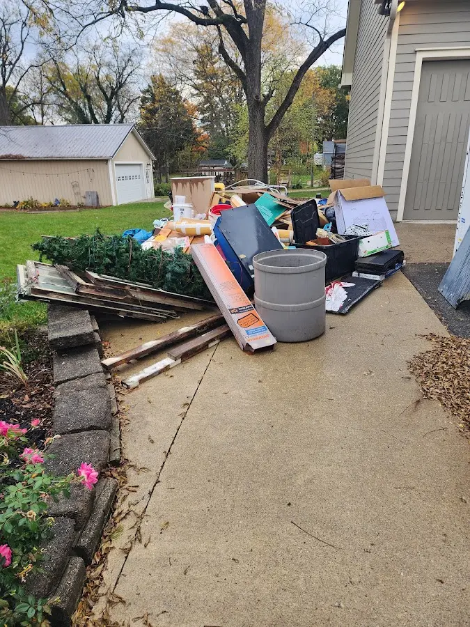 Dumpster being loaded with debris for 12 Yard Dumpster Rental in Johnson Creek